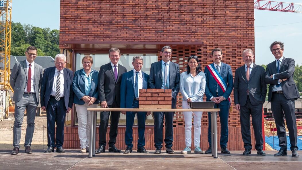 Photo de Hermes qui pose la première pierre
