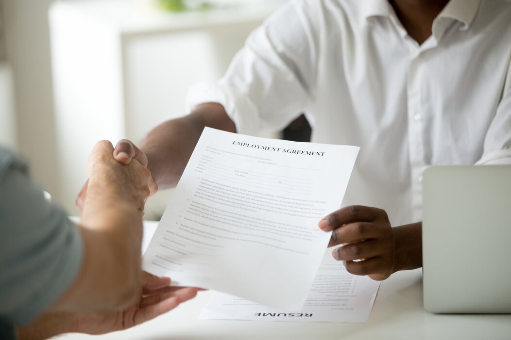 Photo d'un employeur remettant un contrat à son employé