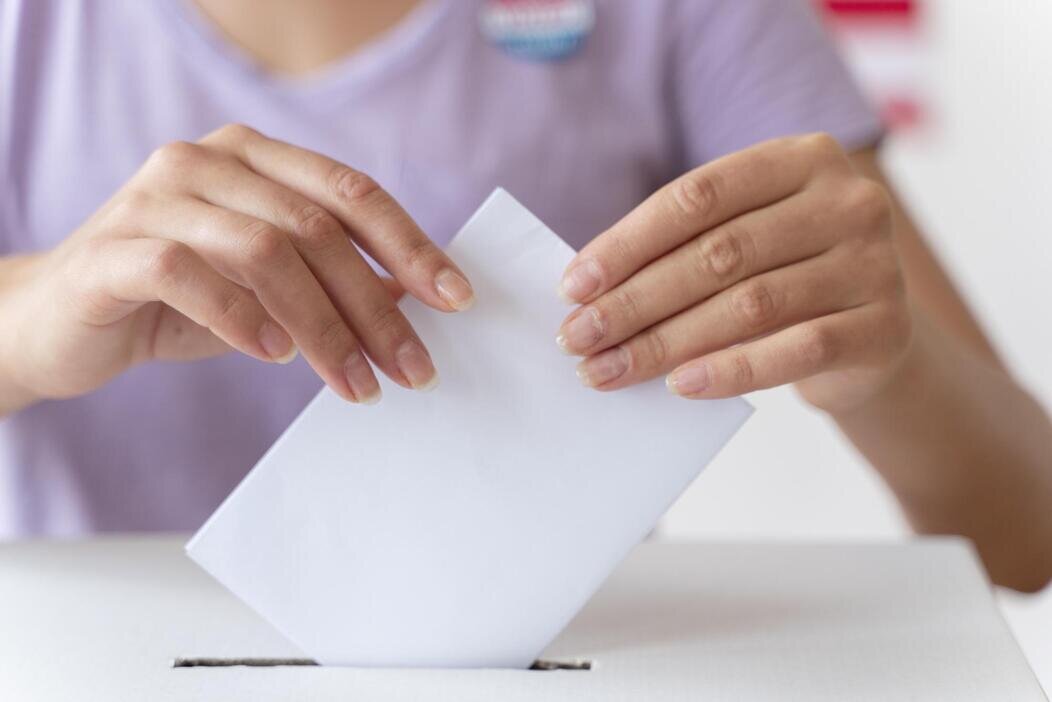 Photo d'une personne mettant son vote dans une urne